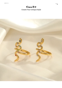 Macro detail of gold snake rings with colorful rhinestones on silk background