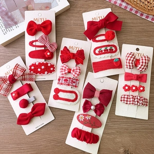 Detailed view of red fabric bow hairpins and knitted flower clips on a display card