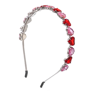 Detail view of heart gemstones on a silver metal headband with red and pink crystals