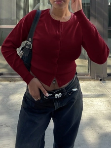 Détail du cardigan rouge en tricot à manches longues avec boutons simples et coupe ajustée