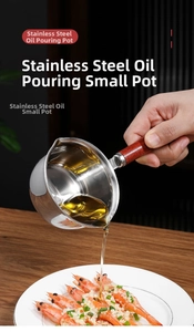 Chef pouring hot oil from a stainless steel mini pan with wood handle onto garlic shrimp