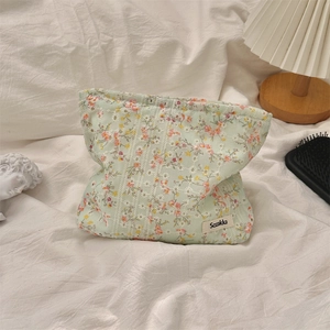 Floral canvas makeup bag on white fabric with warm ambient home decor background