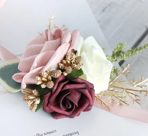 Detailed close-up of wedding wrist corsage with pink, white and burgundy silk roses