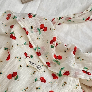 Gros plan sur la texture seersucker à motif cerise et l'étiquette de marque en tissu