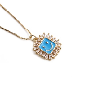 Golden necklace featuring a blue enamel smiley face pendant framed by clear zircon stones