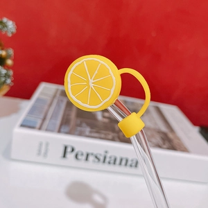 Detail of yellow lemon silicone straw topper on glass straw with dustproof cap cover