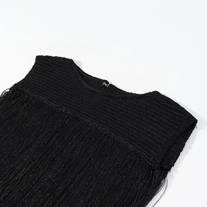 Détail du col rond et des franges multicouches sur une robe de soirée en maille noire