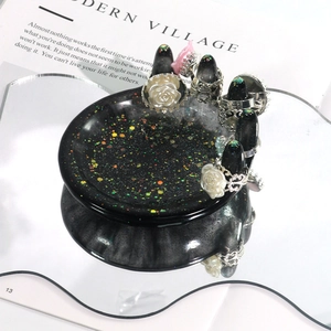 Macro detail van een zwart glitterhars handvormig sieradendisplay voor ringopslag