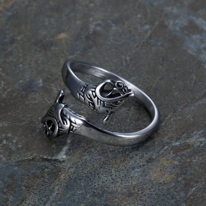Adjustable silver Viking wolf head ring with vintage relief on grey stone backdrop