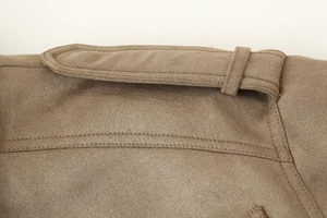 Detailed macro view of the khaki faux suede texture and stitching on the jacket epaulette