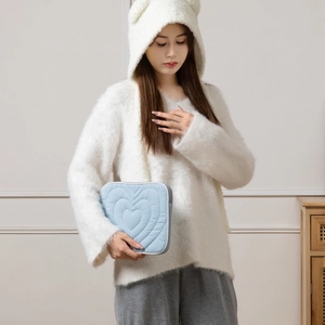 Detail of light blue quilted iPad sleeve with heart stitching and white zipper closure