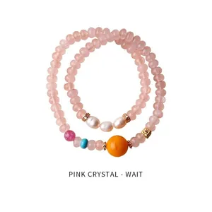 Close-up of pink crystal bead bracelets with pearls and gold-plated zircon charms