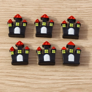 Detailed view of black Halloween resin castle charms for DIY phone cases and crafts