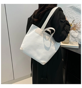 Detail of off-white corduroy tote bag showing thick texture and leather reinforced corners