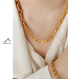 Close-up of gold-plated stainless steel geometric link necklace worn by a model
