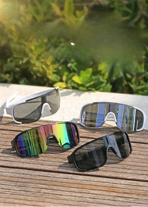 Outdoor sports sunglasses in multiple colors displayed on a wooden deck with sunlight