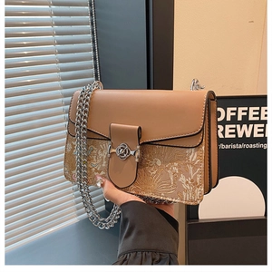 Detailed view of an elegant chain strap small square bag with textured jacquard fabric