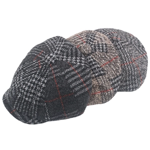 Three men's wool houndstooth newsboy caps in grey and camel tones on white background