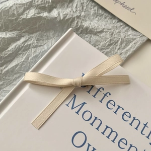 Elegant white bow hair clip on a hardcover book for a sweet princess hair style