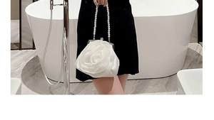 Detail einer weißen Abendtasche in Rosenform mit elegantem Griff aus Perlenketten