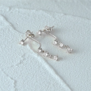 Close-up of S925 sterling silver earrings featuring hanging zircon tassels on stone