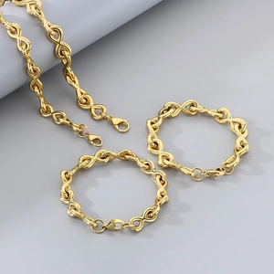 Macro detail of golden infinity link necklace and bracelets with polished metallic finish