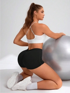 Close-up of seamless high-waisted yoga shorts with lifting effect and cross-back sports bra
