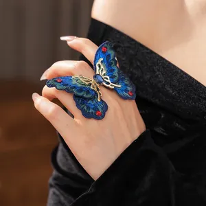 Vintage gold butterfly ring with blue embroidery and crystals on hand view