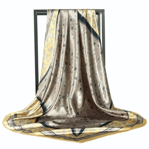 90cm leopard and chain print satin silk scarf in gold and grey hanging on a metal rack