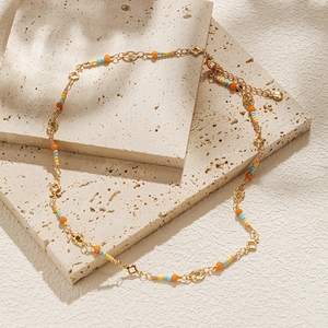 Detail of 18K gold plated necklace with colorful beads and star charms on stone