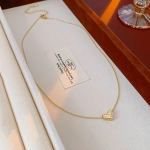 Close-up of heart pendant necklace with textured finish in elegant jewelry box