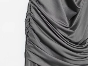 Detail of the side ruching and fine knitted texture on a dark grey maxi dress