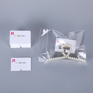 White minimalist paper display cards with red bow for jewelry packaging and hair clips