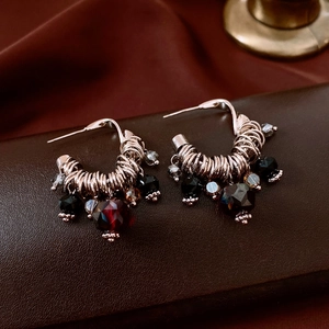 Detailed macro view of vintage C-shaped earrings with silver wire wrap and glass beads