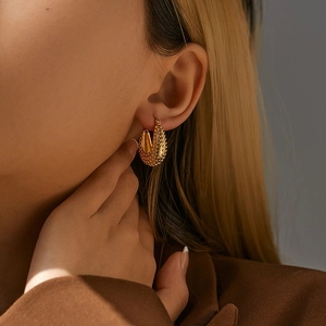 Vintage 18K gold plated brass oval earrings with granular texture shown on model