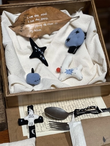 Detail view of handmade cotton embroidery brooches with Love Peace text in a vintage box