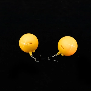 Close-up of yellow 70s retro disco ball earrings with metallic textured surface details