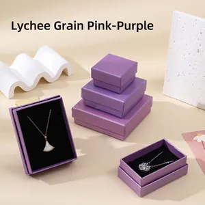 Macro view of purple linen textured jewelry boxes with black velvet interior for necklaces