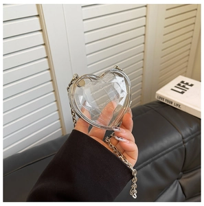Detail shot of heart-shaped transparent acrylic mini bag with silver metal chain strap