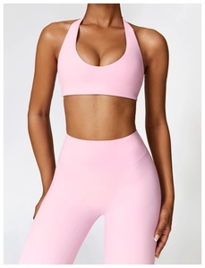 Detail of pink high-waisted yoga pants and halter sports bra set with matte texture