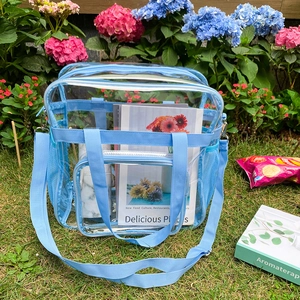Outdoor-Aufnahme der transparenten PVC-Umhängetasche mit blauem Stoffrand bei Hortensien
