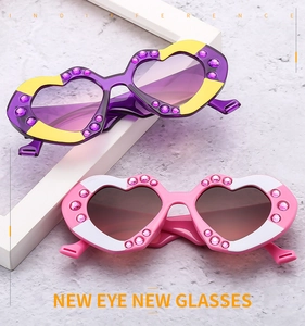 Detail view of heart-shaped sunglasses with inlaid rhinestones in purple and pink tones