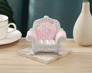 Pink velvet sofa jewelry stand with white resin frame and pearl earrings display