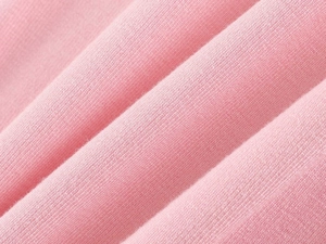 Close-up of pink breathable knit fabric texture with soft folds on a camisole sleepwear set