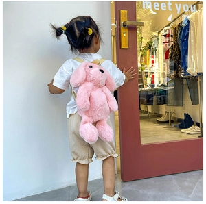 Pink plush puppy backpack shown on a child model with soft faux fur and yellow straps