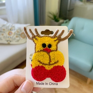 Handmade crochet Christmas reindeer hair clip pin on white card with knit texture details