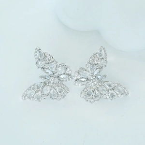 Elegant silver butterfly earrings with sparkling zircon crystals on a soft background