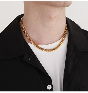 Close-up of a thick golden stainless steel Cuban link necklace worn by a male model
