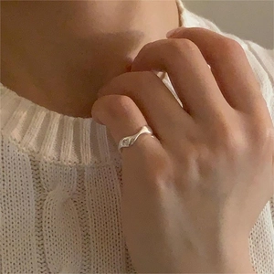 Close-up of minimalist S925 sterling silver irregular wave ring on model hand
