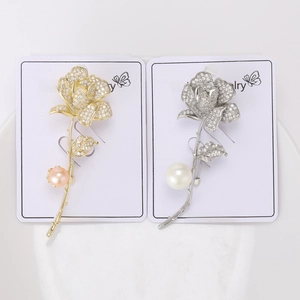 Détail de broches roses élégantes avec oxydes de zirconium et perles dorées et argentées
